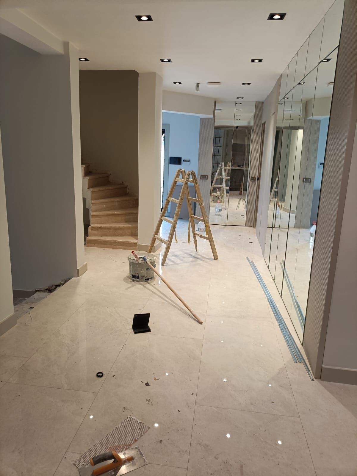 Boya badana işi süren aydınlık villa holü: merdiven, boya kovası ve rulo sopası